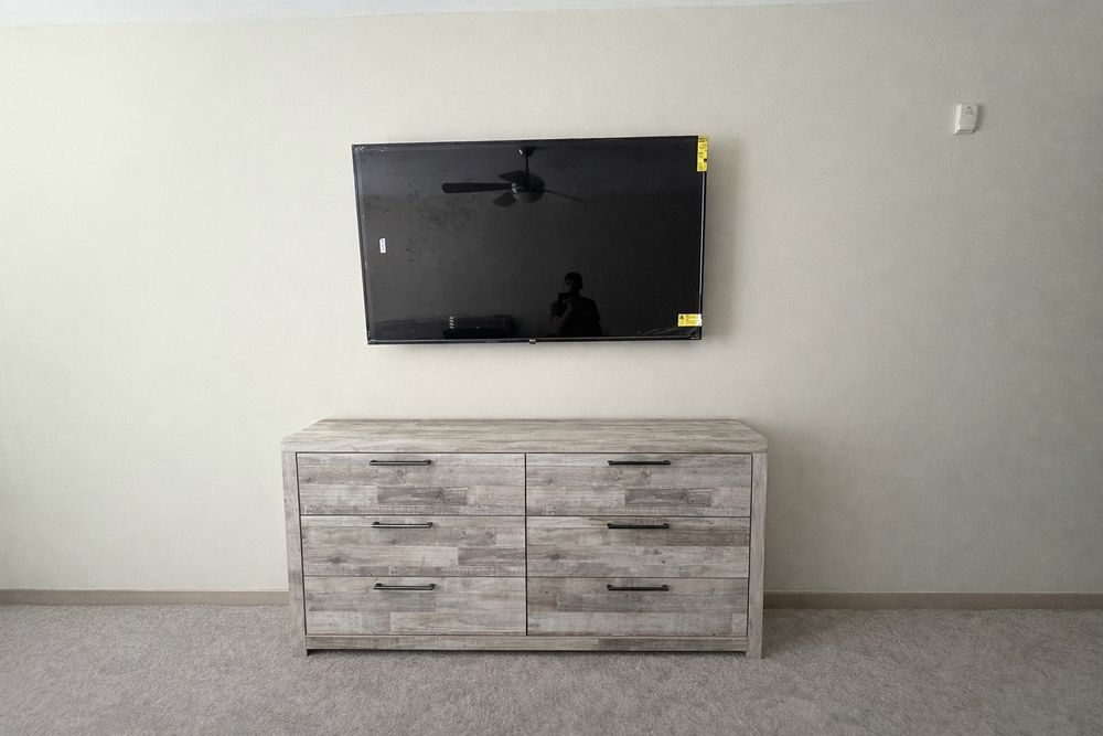 Flat-screen TV mounted cleanly above a dresser